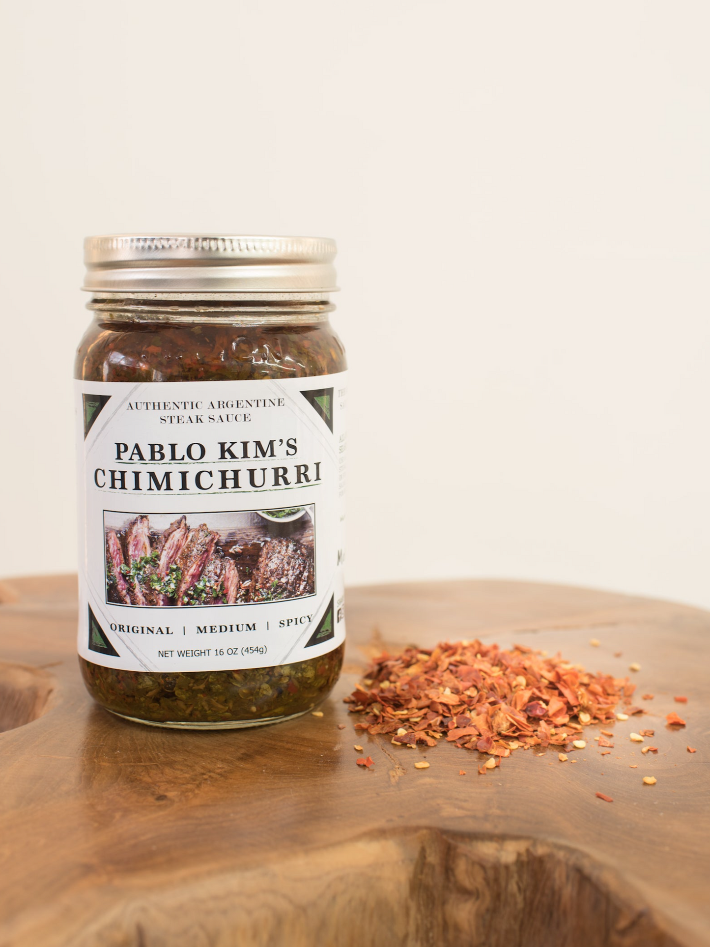 Medium Chimichurri jar 16 oz with chili flakes next to it