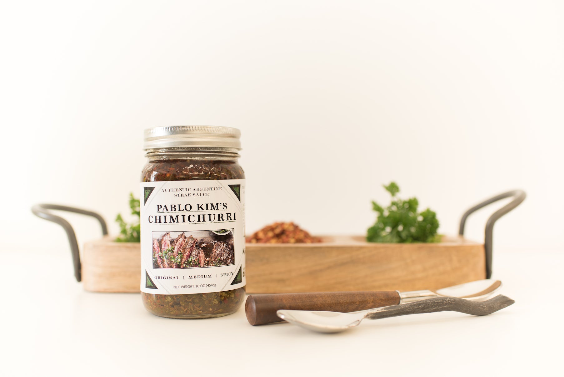 16 oz chimichurri jar with 2 spoons and a wood tray